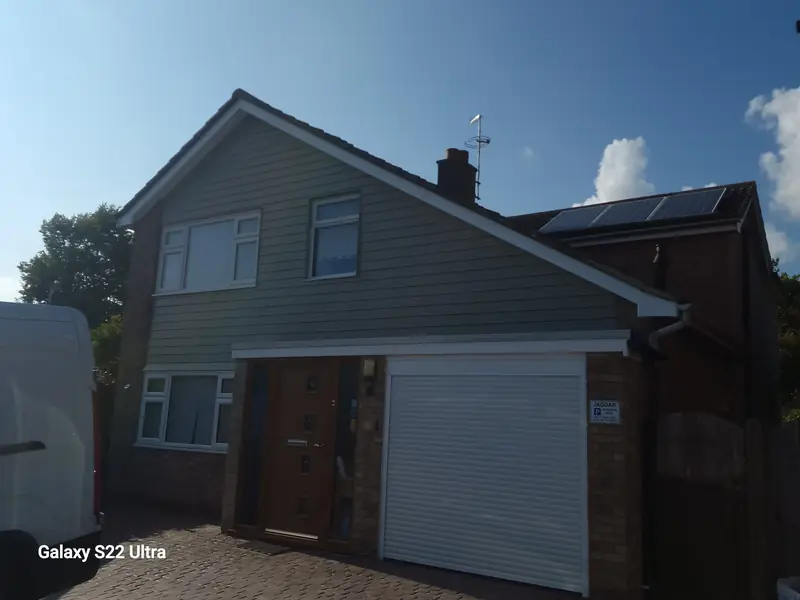 Detached house in West Bergholt with new sage-green horizontal cladding across the upper front elevation