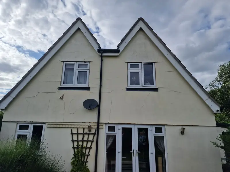 Twin rear gables of a house in Ardleigh with cracked cream render