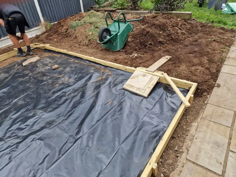 Timber formwork with a damp-proof membrane laid over levelled ground for a new base in a Lexden garden