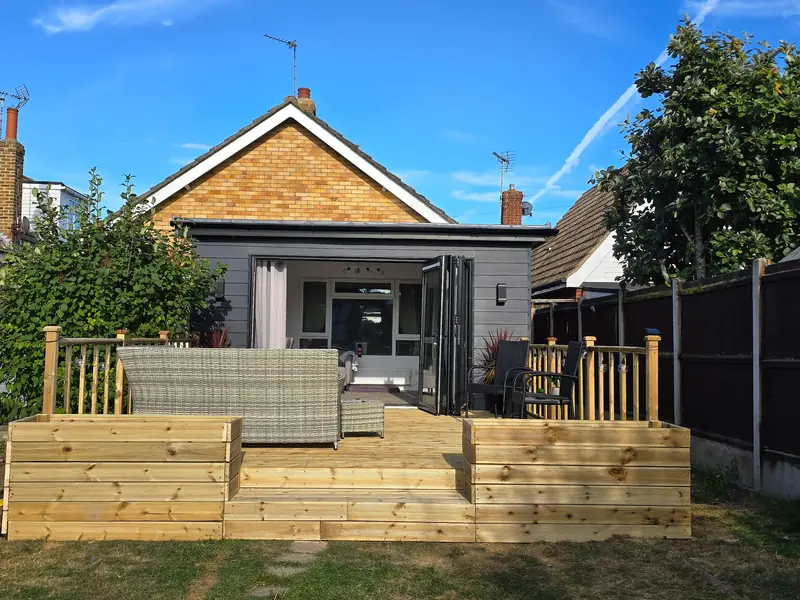 Front view of the Clacton-on-Sea deck showing the wide steps, planters and balustrade outside bi-fold doors