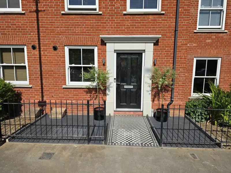 Black and white mosaic tiled front path with grey tiled areas either side, behind railings at a Colchester town house