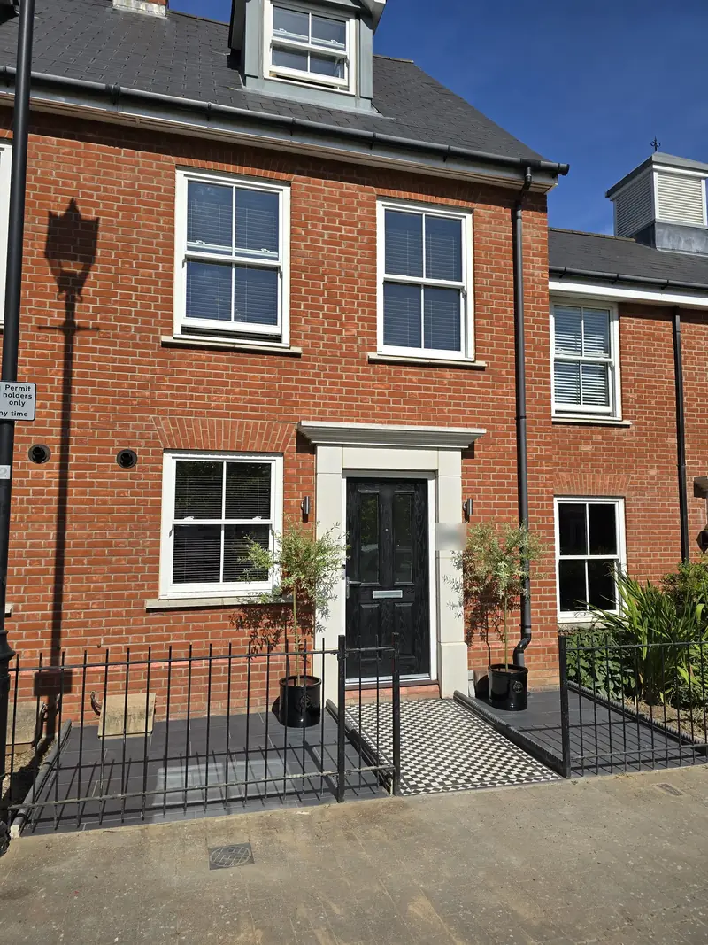 Three-storey Colchester town house with a new mosaic path, grey tiled front garden and potted trees by the door