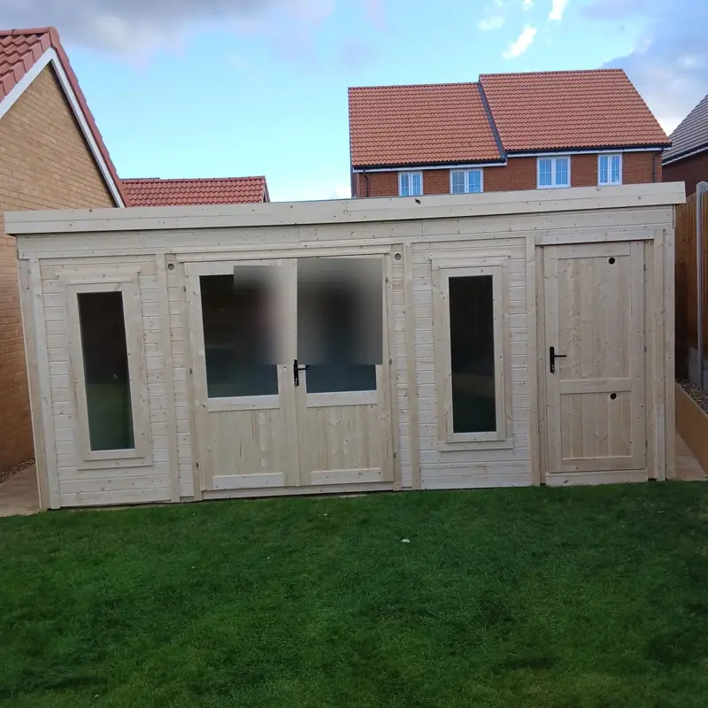 Finished timber clad garden office with double doors, two tall windows and a separate store door, set on a green lawn